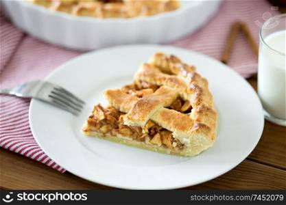 food, culinary and baking concept - close up of apple pie and fork on plate. close up of apple pie and fork on plate