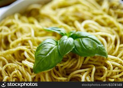 food, culinary and eating concept - close up of cooked pasta with basil leaves. close up of cooked pasta with basil leaves