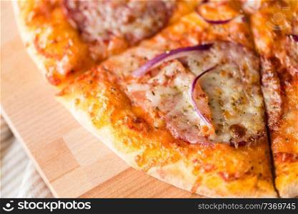 food, culinary and eating concept - close up of sliced homemade pizza on wooden table. close up of homemade pizza on wooden table