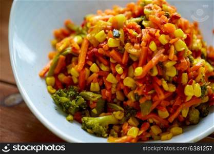 food, culinary and eating concept - close up of vegetable salad in bowl on wooden table. close up of vegetable salad in bowl
