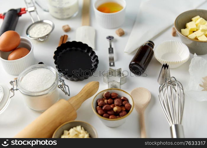 food, culinary and recipe concept - cooking ingredients and kitchen tools for baking on table. cooking ingredients and kitchen tools for baking