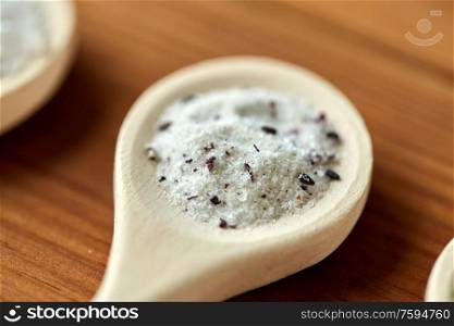 food, culinary and unhealthy eating concept - close up of wooden spoon with flavored salt. close up of wooden spoon with flavored salt