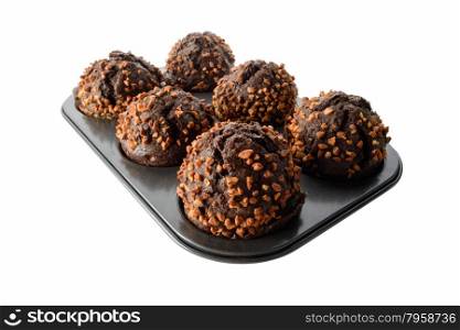 Food: dark chocolate muffins with roasted peanuts in baking pan, isolated on white background