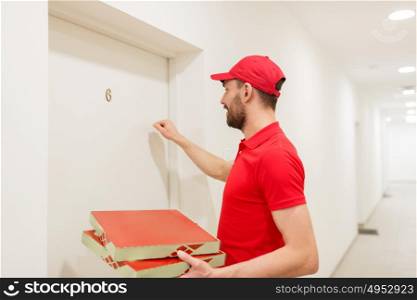 food delivery, mail and people concept - man delivering pizza in paper boxes to customer home and knocking on door. delivery man with pizza boxes knocking on door