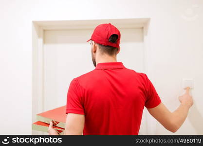 food delivery, mail and people concept - man delivering pizza in paper boxes to customer home and ringing doorbell. delivery man with pizza boxes ringing doorbell