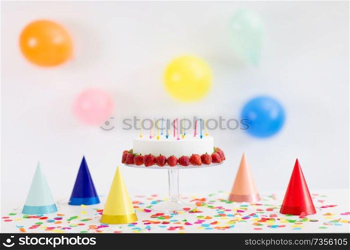 food, dessert and party concept - birthday cake with candles and strawberries on stand. birthday cake with candles and strawberries