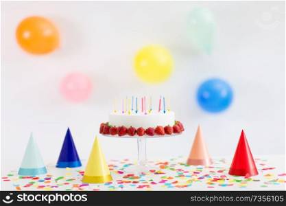 food, dessert and party concept - birthday cake with candles and strawberries on stand. birthday cake with candles and strawberries