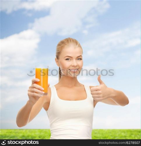 food, diet and healthcare concept - smiling woman holding glass of orange juice and showing thumbs up