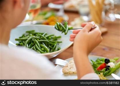food, diet and vegetable concept - close up of woman eating green beans. close up of woman eating green beans