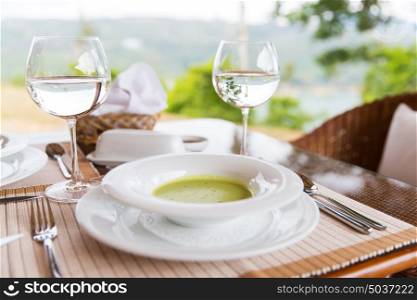 food, dinner and eating concept - plate of cream soup and glasses of water at restaurant. plate of cream soup at restaurant