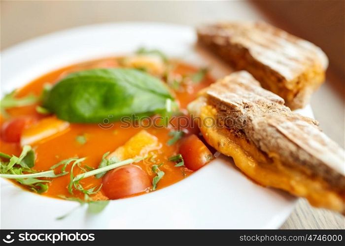 food, dinner, culinary, haute cuisine and cooking concept - close up of plate with delicious gazpacho soup and bread at restaurant