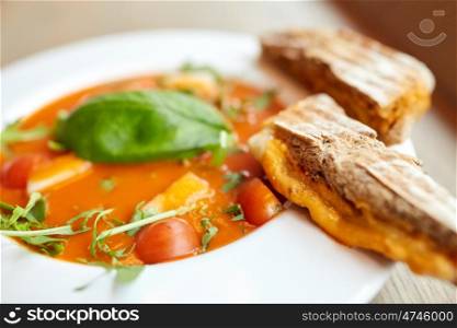 food, dinner, culinary, haute cuisine and cooking concept - close up of plate with delicious gazpacho soup and bread at restaurant