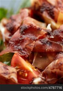 food, dinner, haute cuisine and eating concept - close up of prosciutto ham salad
