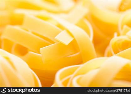 Food: dried italian pasta, fettuccine nests, abstract food background, closeup shot, selective focus, intentional blur