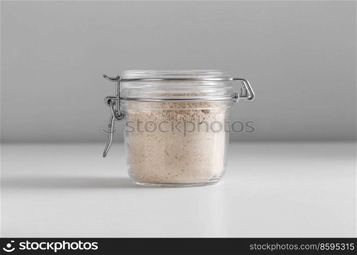 food, eating and cooking concept - jar with almond flour on white background. close up of jar with almond flour on white table