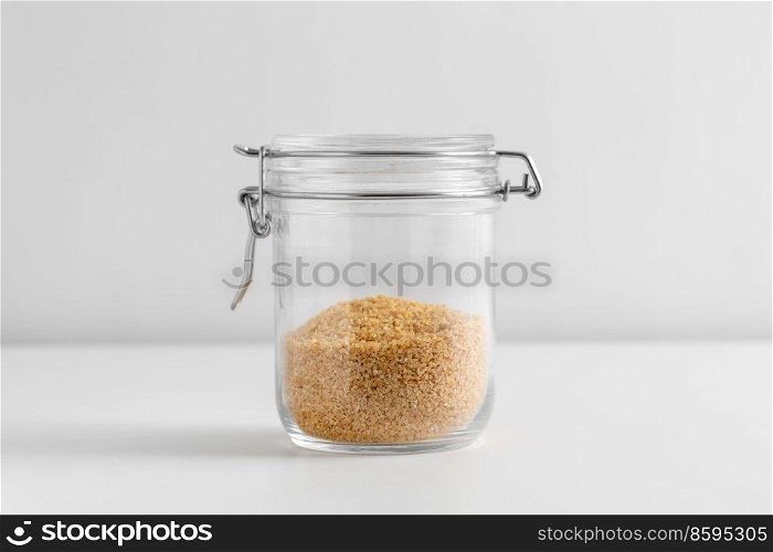 food, eating and cooking concept - jar with bulgur on white background. close up of jar with bulgur on white table
