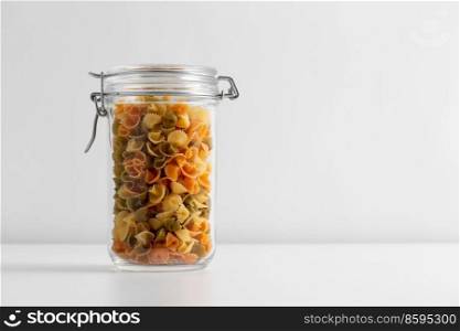 food, eating and cooking concept - jar with pasta on white background. close up of jar with pasta on white table