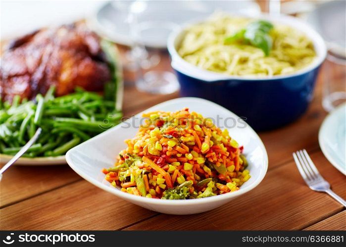 food, eating and culinary concept - bowl of vegetable salad with corn on wooden table. vegetable salad with corn and other food on table