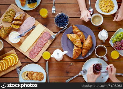 food, eating and family concept - group of people having breakfast and sitting at table. group of people having breakfast at table