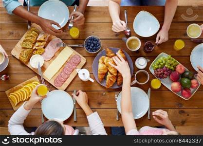 food, eating and family concept - group of people having breakfast and sitting at table. group of people having breakfast at table