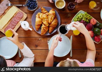 food, eating and family concept - women having breakfast and sitting at table. women having breakfast at table