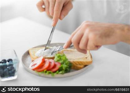 food, eating and people concept - close up of man having toasts with poached egg and vegetables for breakfast. close up of man having toasts for breakfast