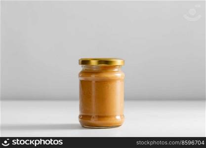 food, eating and preserve concept - close up of jar with canned vegetable puree or peanut butter on table. close up of jar with canned peanut butter