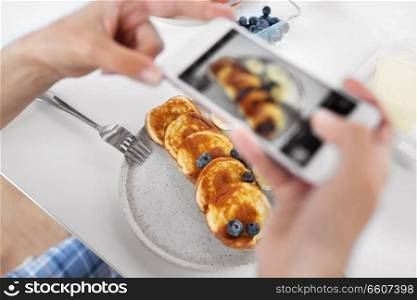 food , eating and technology concept - hands with smartphones photographing breakfast on plate. hands with smartphones photographing food