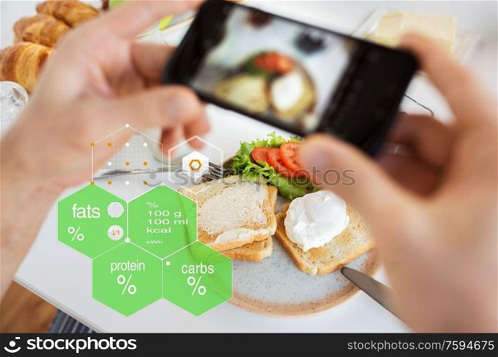 food, eating and technology concept - hands with toasts and vegetables on smartphone screen over nutritional value chart. hands with food on smartphone screen