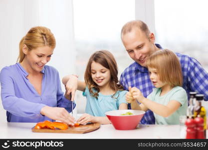 food, family, children, hapiness and people concept - happy family with two kids making dinner at home