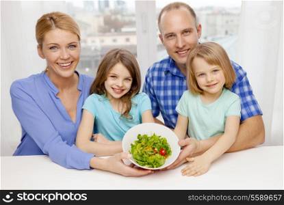 food, family, children, happiness and people concept - happy family with two kids with salad at home