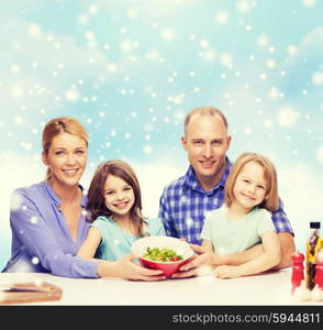 food, family, children, happiness and people concept - happy family with two kids showing salad in bowl over blue sky and snowflakes background