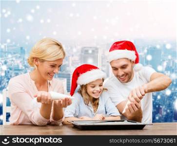 food, family, christmas, happiness and people concept - smiling family in santa helper hats with glaze and pan cooking over snowy city background