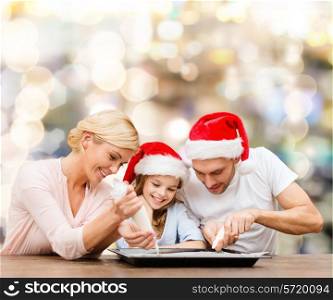 food, family, christmas, happiness and people concept - smiling family in santa helper hats with glaze and pan cooking over lights background