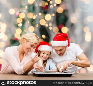 food, family, happiness and people concept - smiling family in santa helper hats with glaze and pan cooking over christmas tree lights background