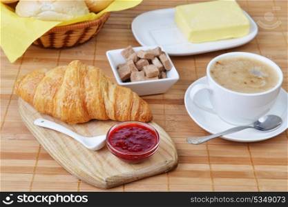 food for breakfast. buns, croissant and cup of coffee