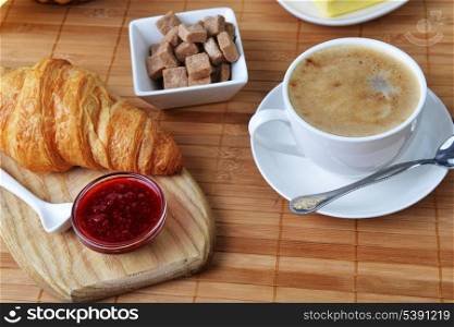 food for breakfast. buns, croissant and cup of coffee
