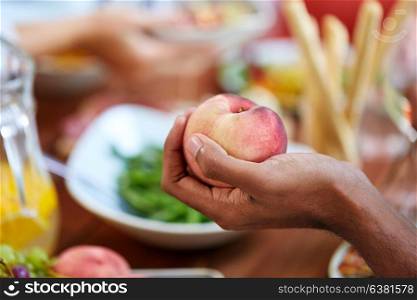 food, fruit and healthy eating concept - male hand holding peach. male hand holding peach