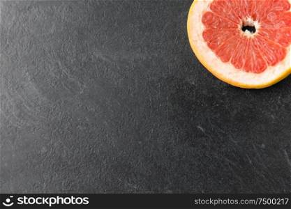 food, fruits and healthy eating concept - close up of fresh juicy grapefruit on slate background. close up of fresh juicy grapefruit on slate board