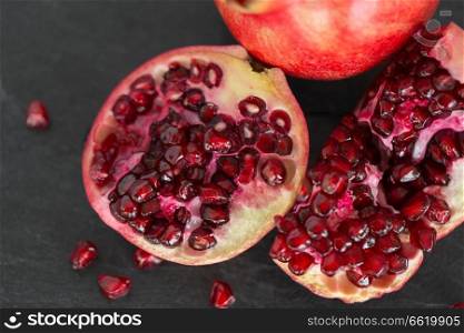 food, fruits and healthy eating concept - close up of pomegranate on stone table. close up of pomegranate on stone table