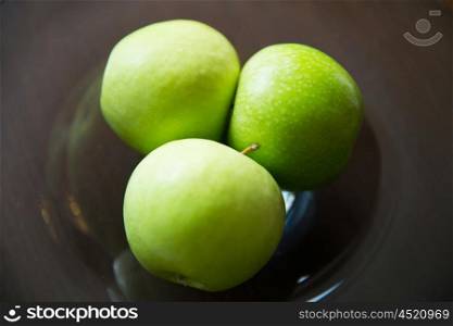 food, fruits, diet and healthy eating concept - close up of green apples on glass plate