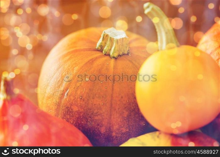 food, harvest, season and autumn concept - close up of pumpkins on wooden table at home. close up of pumpkins on wooden table at home