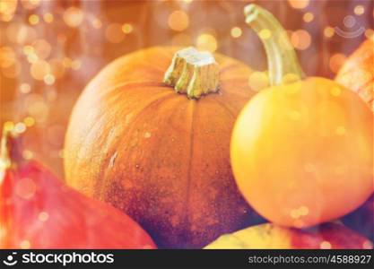 food, harvest, season and autumn concept - close up of pumpkins on wooden table at home. close up of pumpkins on wooden table at home