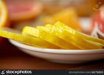 food, health, traditional medicine, folk remedy and ethnoscience concept - close up of lemon slices on plate