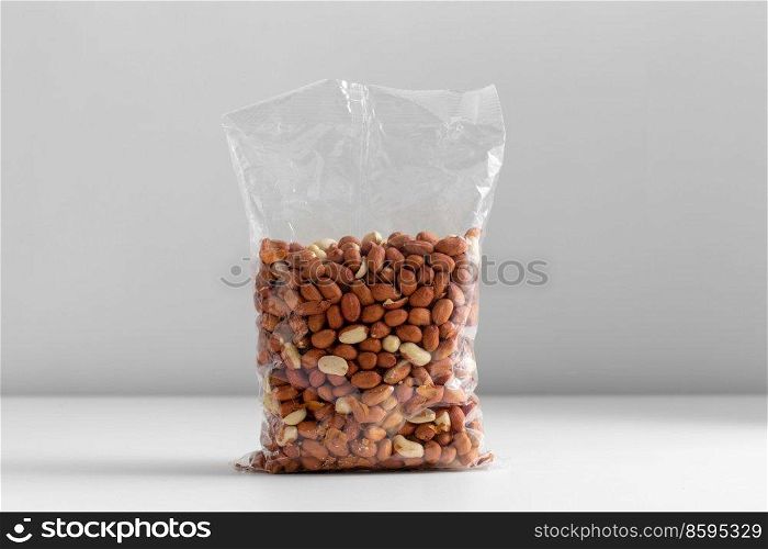 food, healthy eating and diet concept - bag with raw peanuts on white background. close up of bag with peanuts on white table