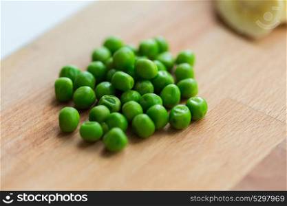 food, healthy eating and diet concept - close up of green pea on wooden cutting board. close up of green pea on wooden cutting board