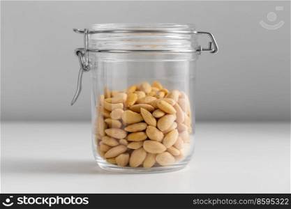 food, healthy eating and diet concept - jar with almonds on white background. close up of jar with almonds on white table
