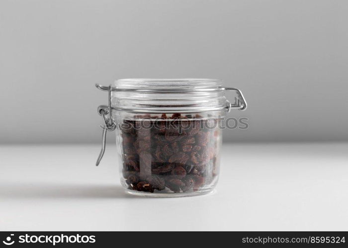 food, healthy eating and diet concept - jar with raisin on white background. close up of jar with raisin on white table