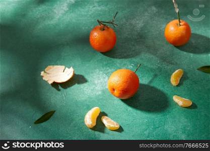 food, healthy eating and fruits concept - still life with mandarins on green background. still life with mandarins on green background