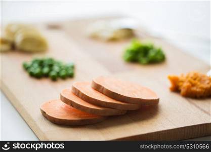 food, healthy eating and nutrition concept - sliced pumpkin and other vegetables on wooden board. sliced pumpkin on wooden board